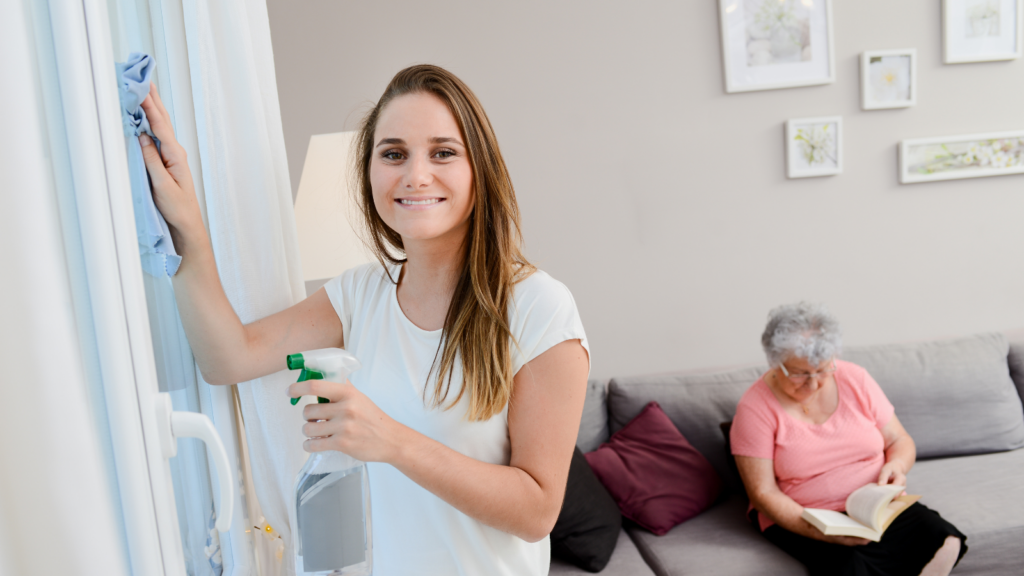 As domestic assistance, a woman cleans the glass doors.