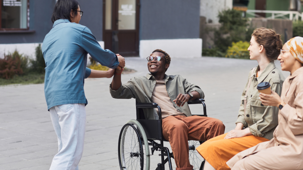 People in group programs coordinate service with a disabled man in a wheelchair.